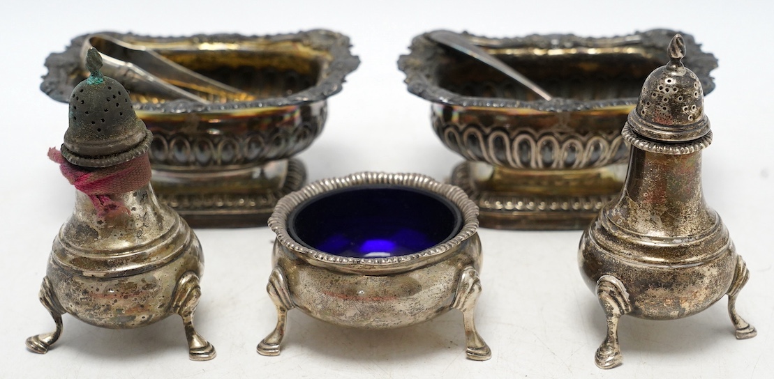 A George III silver three piece condiment set, Story & Elliot, London 1810/11, together with a George V silver five piece condiment set, Harrod's Ltd, London, 1911. Condition - fair